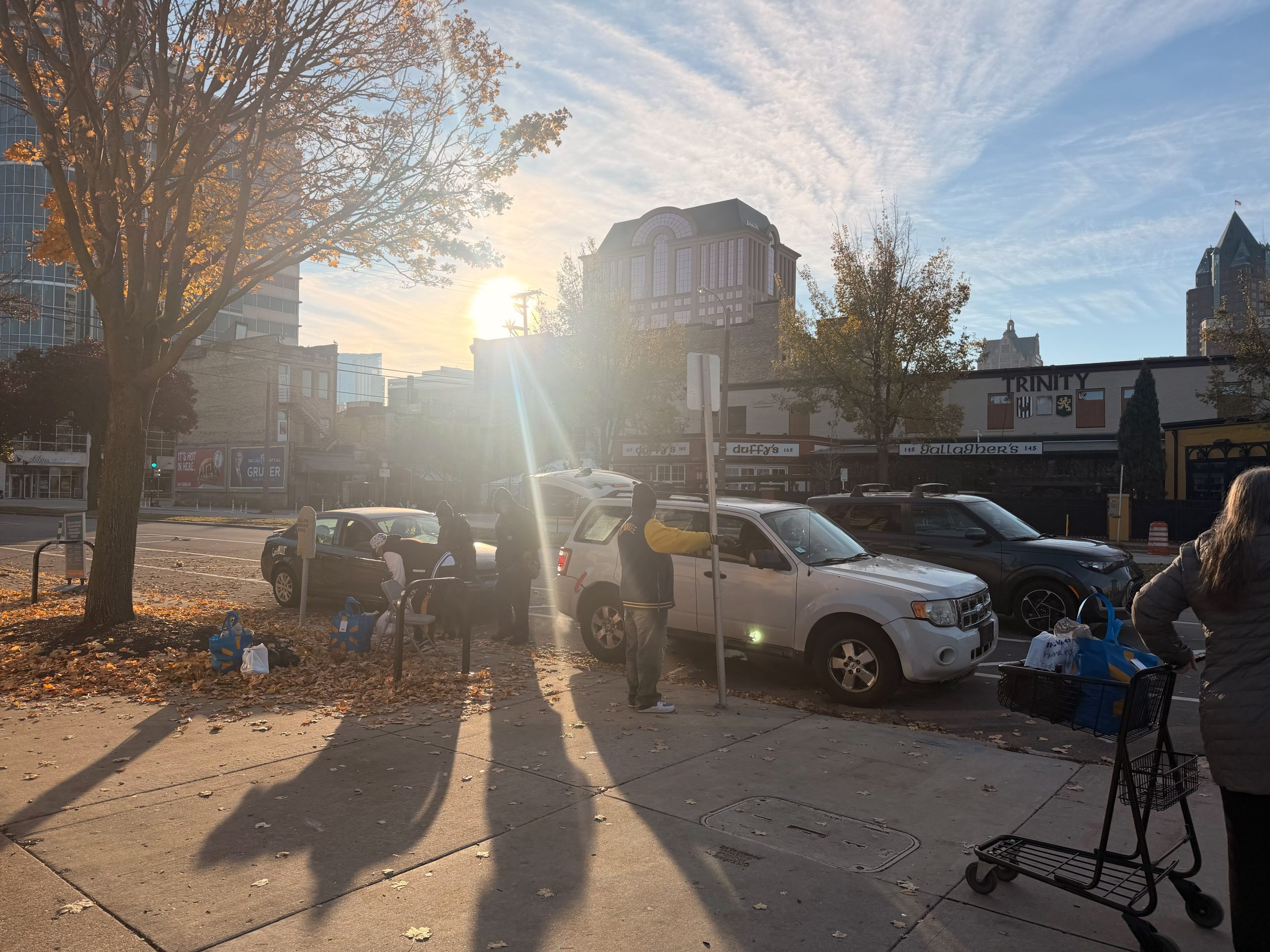 Volunteers loading grocery bags into cars during the Thanksgiving food distribution