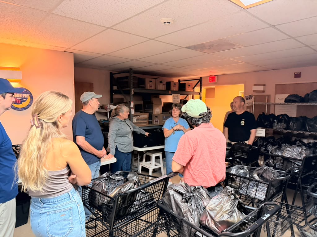 Rotaract Club of Milwaukee volunteers receive a briefing from Interchange Food Pantry staff before their shift