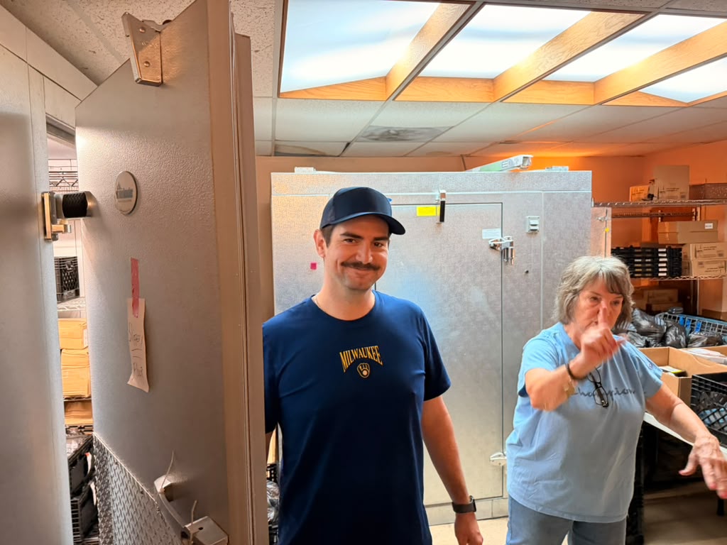 Rotaract Club of Milwaukee volunteers near the walk in cooler at Interchange Food Pantry